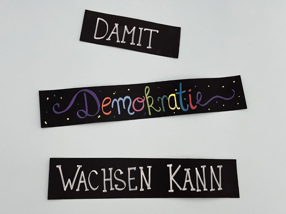 Handgeschriebene Worte "Damit Demokratie wachsen kann"