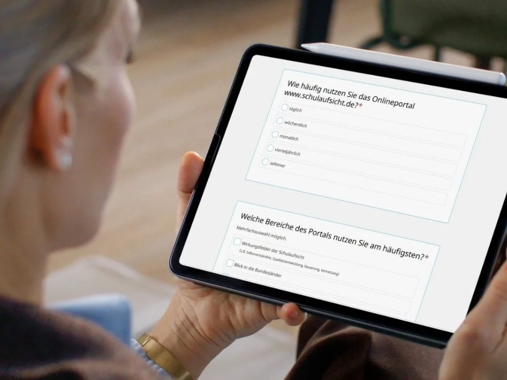 Eine Frau schaut auf ein Tablet, auf dem die Nutzer:innenbefragung geöffnet ist
